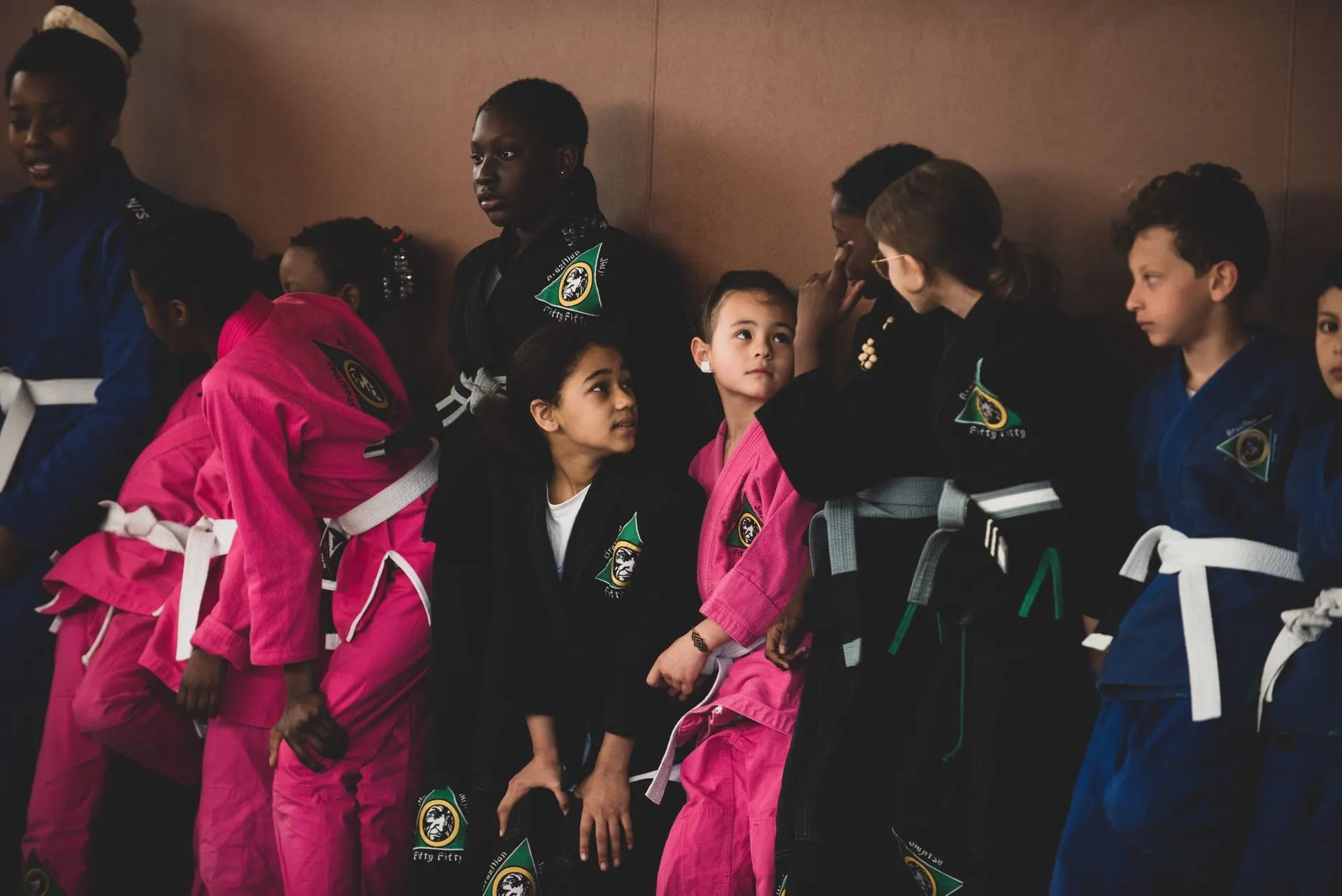 Les enfants assis en rang au bord du tapis