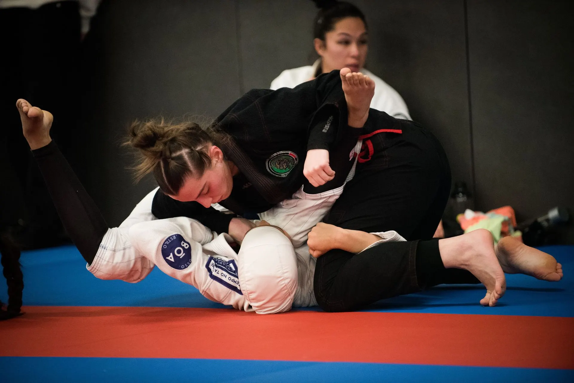 Deux pratiquantes en combat au sol pendant un cours féminin