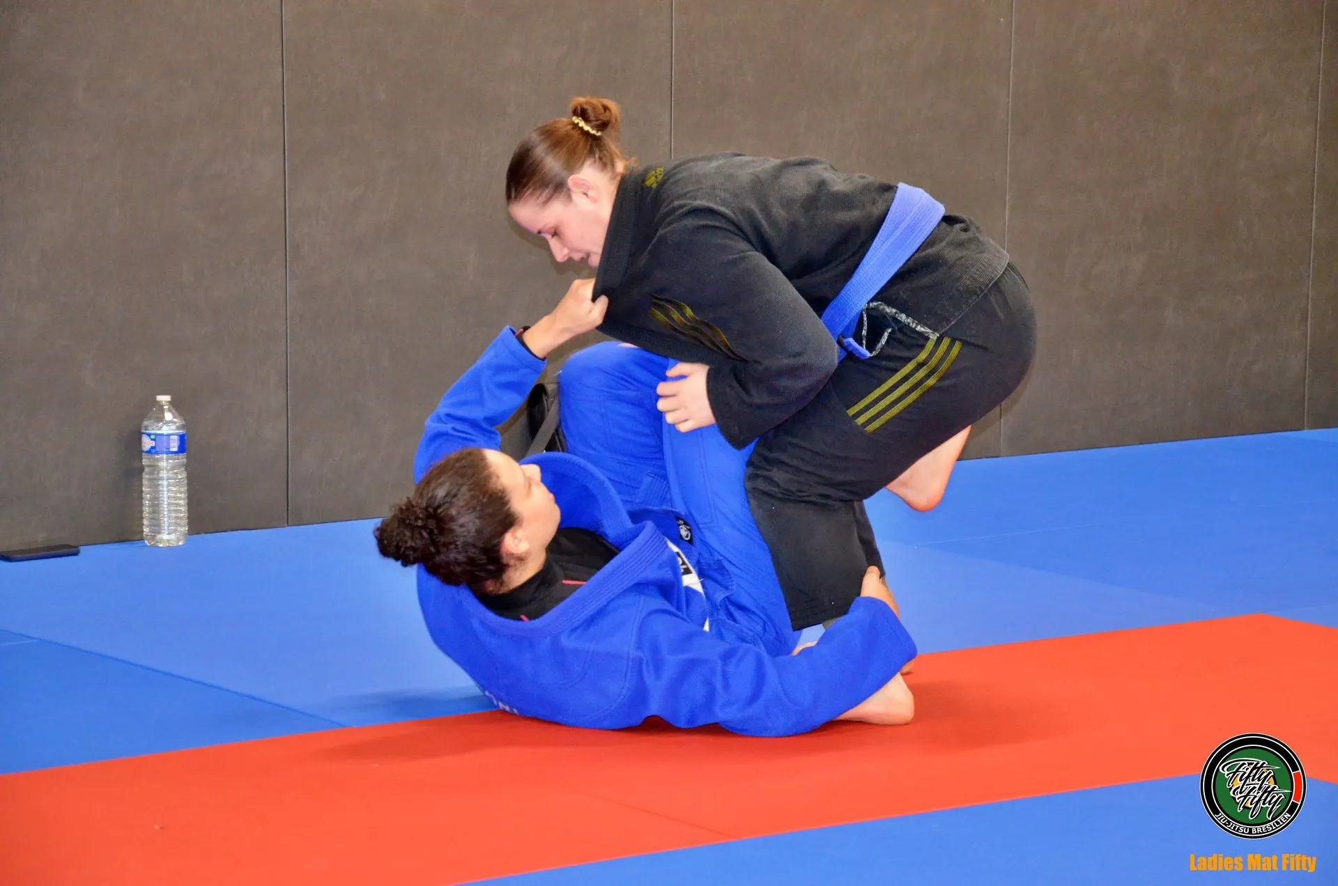Deux pratiquantes en kimono bleu et noir en combat